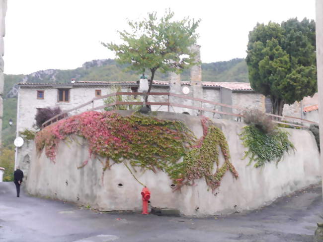 Mur de l'église de cailla dont le presbytère a été transformé en logements, on peut voir le clocher en fond - Cailla (11140) - Aude