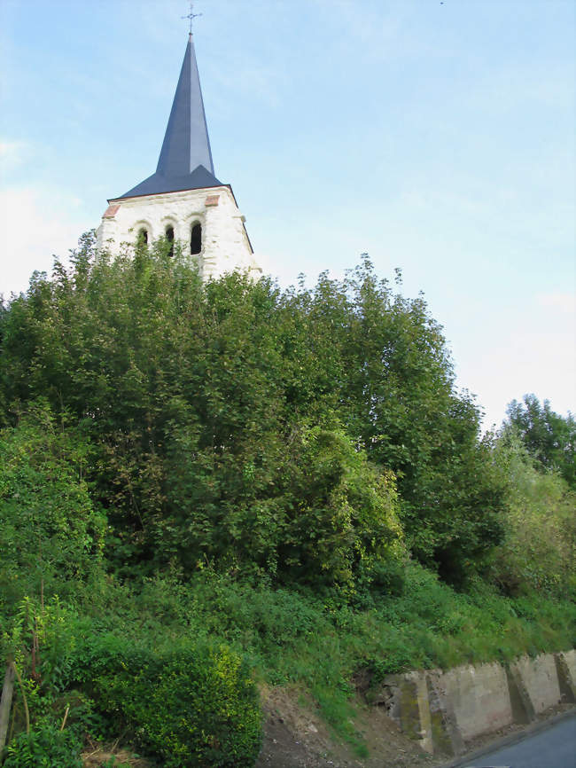 Le clocher de pierre, d'un blanc éclatant dû à une restauration récente, surgit de la butte boisée surplombant une partie du village - Tavaux-et-Pontséricourt (02250) - Aisne