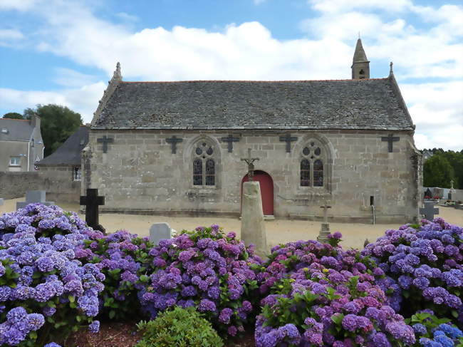 L'église paroissiale et, devant, la borne milliaire trouvée sur la voie romaine, surmontée d'une croix - Loc-Eguiner-Saint-Thégonnec (29410) - Finistère