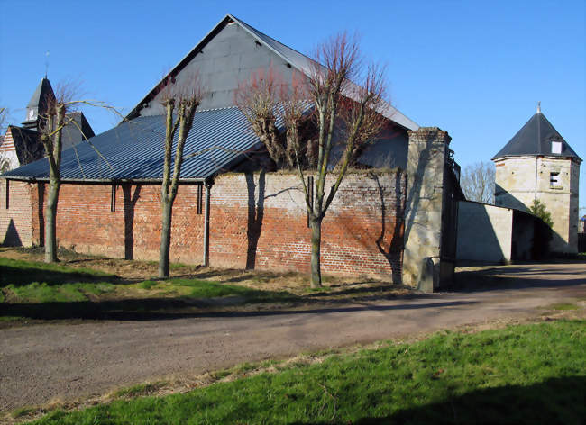 Un colombier se dresse dans une cour de ferme, derrière l'église entourée du cimetière - Louvrechy (80250) - Somme